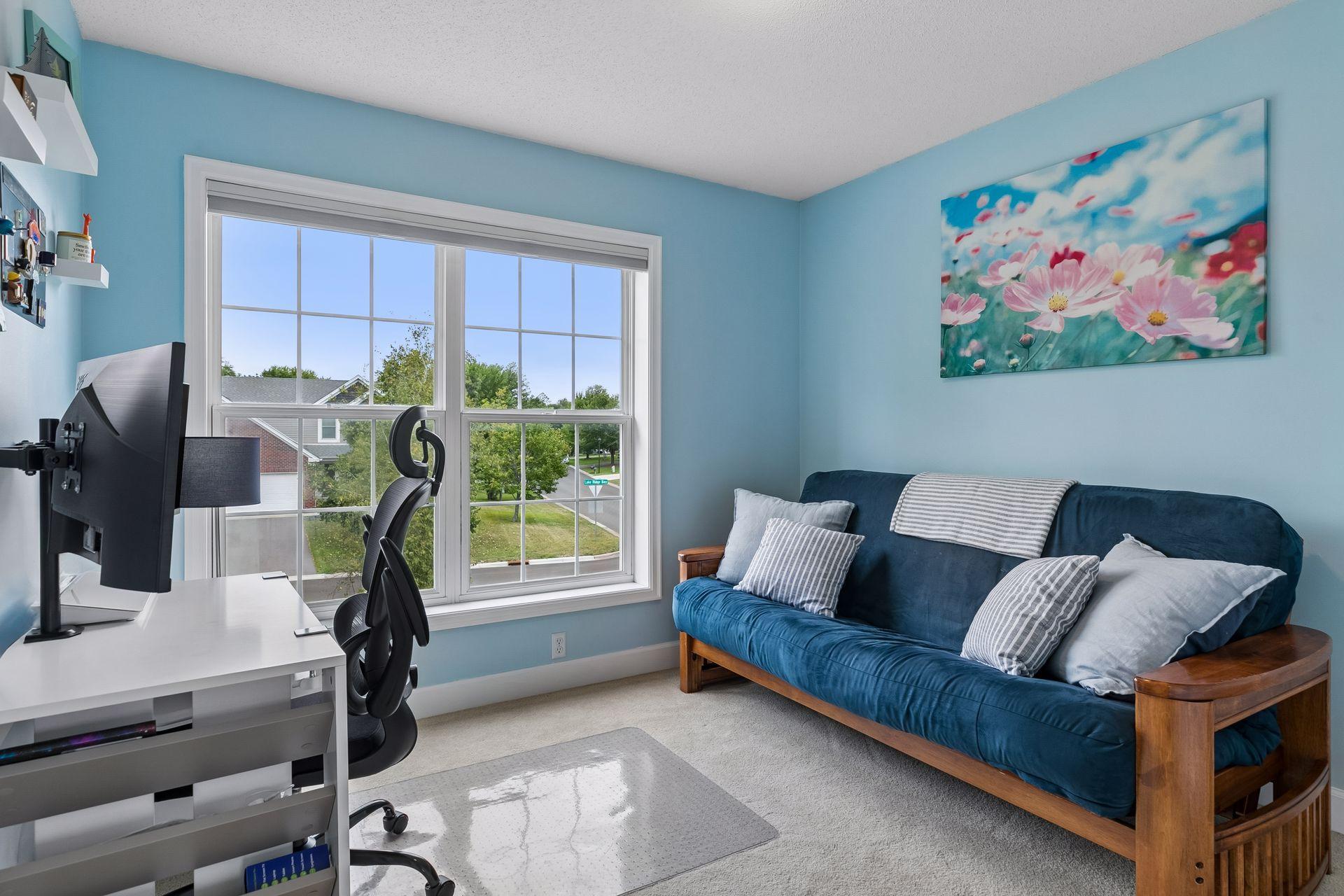 The second of three upper level bedrooms offers excellent flexibility, currently serving as a home office with a large double window, carpet flooring, overhead lighting, and double closet.