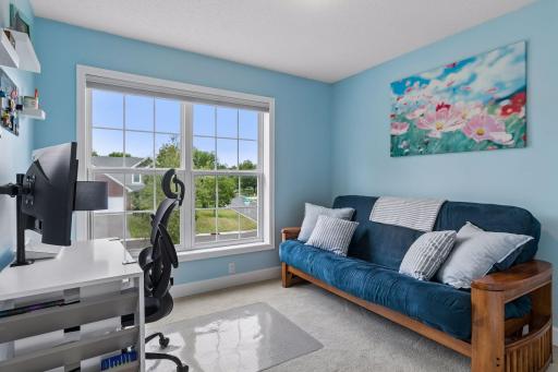 The second of three upper level bedrooms offers excellent flexibility, currently serving as a home office with a large double window, carpet flooring, overhead lighting, and double closet.