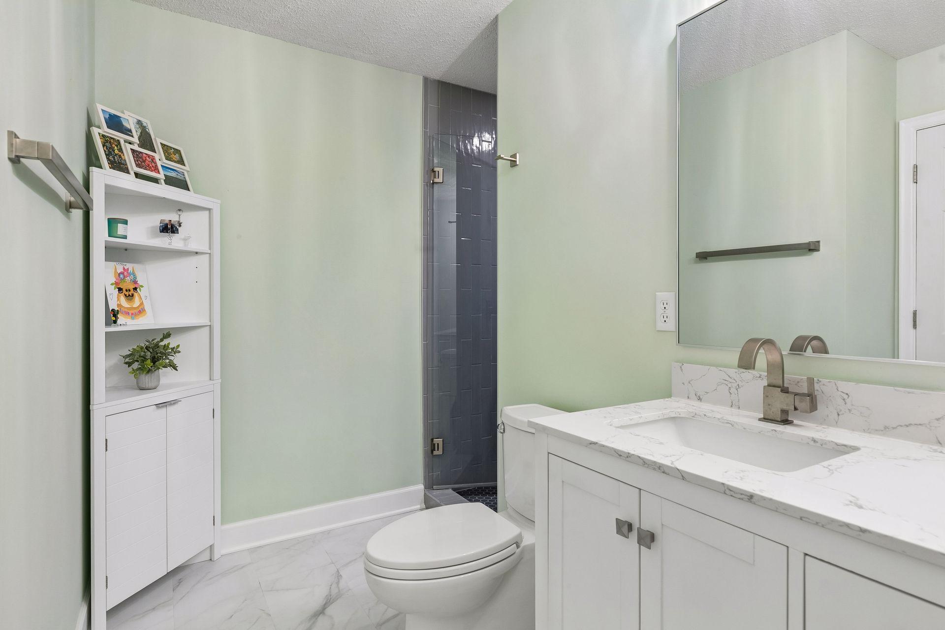 Start and end your day in the beautifully updated primary 3/4 bath, featuring a spacious double vanity, LVP flooring, wall lighting, and a gorgeous tiled shower with a custom glass door.