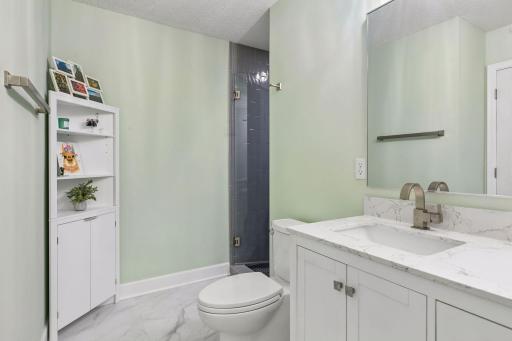 Start and end your day in the beautifully updated primary 3/4 bath, featuring a spacious double vanity, LVP flooring, wall lighting, and a gorgeous tiled shower with a custom glass door.