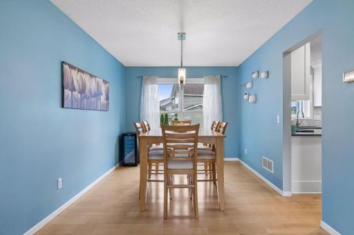 Host everything from holiday dinners to casual gatherings in the formal dining space, complete with two bright windows, stylish chandelier lighting, and the beautiful maple flooring that continues throughout.