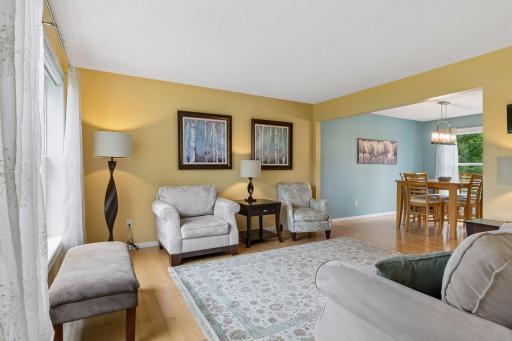 The maple hardwood flooring extends through the living room, creating a seamless connection to the adjacent formal dining room.