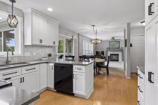 An open layout connects the kitchen to the informal dining space and family room beyond, creating a cohesive setting for everyday living and entertaining.