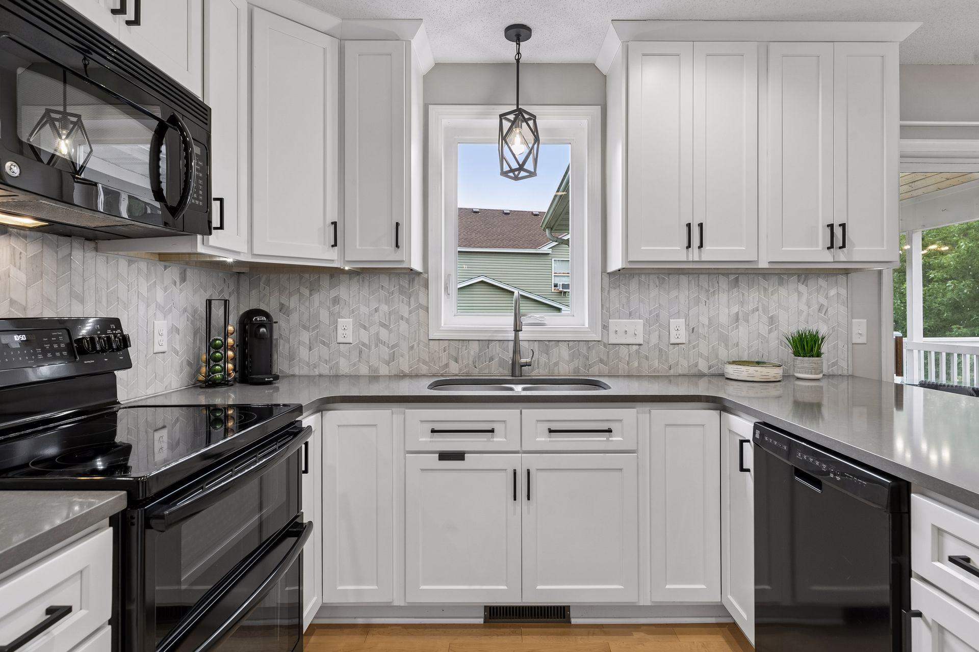 Thoughtful details shine throughout the kitchen, from the stylish pendant light over the double sink to the tile backsplash and double oven.