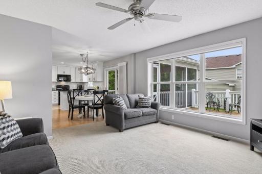 A wall of three oversized windows brightens the family room, with a view looking back to the informal dining space and kitchen.