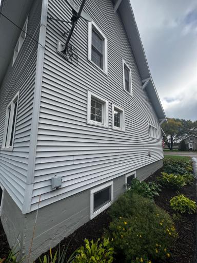 Side of home, poured concrete foundation and easy care perennial flower beds