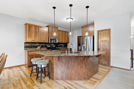Generously sized center island provides additional seating for your family and guests. There is also a convenient pocket door that slides to open the walk-in pantry.
