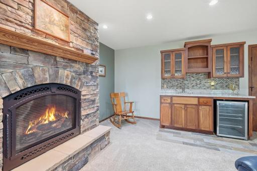 closer view of the stone fireplace and the wet bar