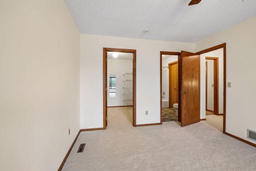 The other side of the primary suite, showing a walk in closet and access to the full bath.