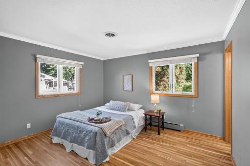 A bright and airy primary bedroom filled with natural light streaming in through multiple windows