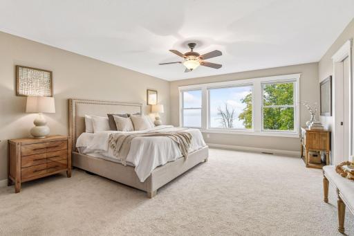 A serene, oversized primary suite features a wall of windows, soft natural light, and plenty of space to create a comfortable private retreat.