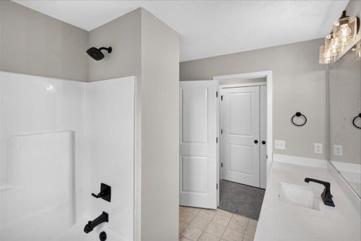 Walk Thru Bathroom. Photo taken of another home with similar plan and finishes.
