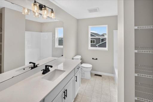 Walk Thru Bathroom. Photo taken of another home with similar plan and finishes.
