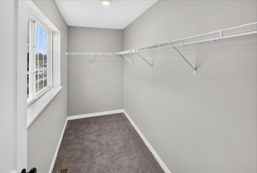 Primary Walk In Closet. Photo taken of another home with similar plan and finishes.