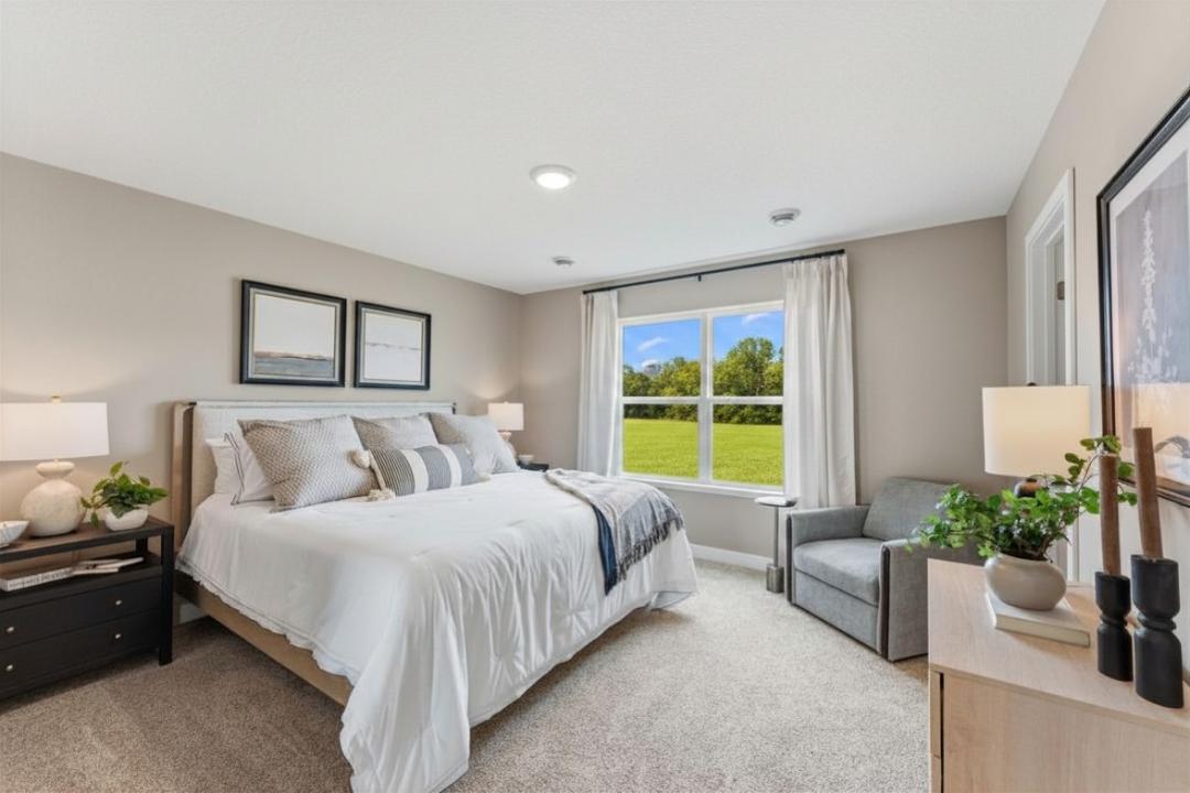 Spacious primary suite with private bath and walk-in closet. Photo of model home. Colors and finishes may vary.