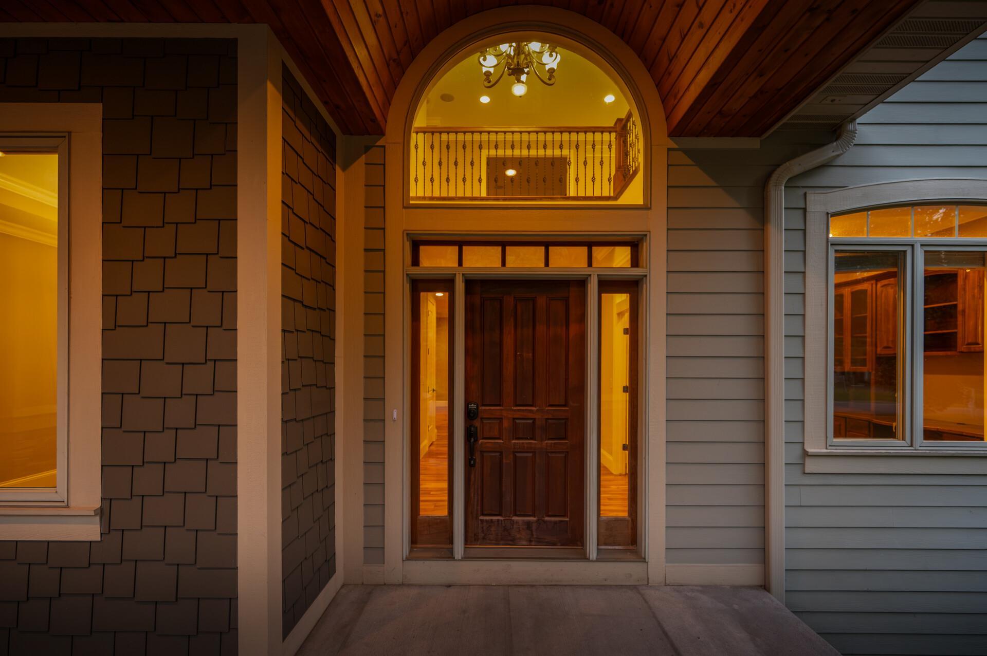 An impressive front entry is framed by dual sidelights and a transom window, while a dramatic half-moon window above draws in even more natural light and adds to the home’s grand sense of arrival.