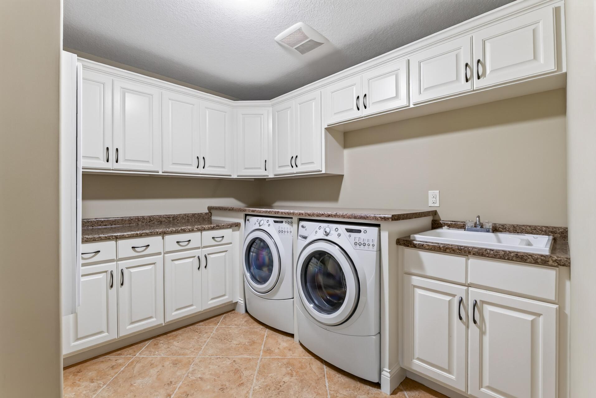 Upper-level laundry makes everyday living effortless, complete with an abundance of cabinetry for exceptional storage and a utility sink for added convenience.