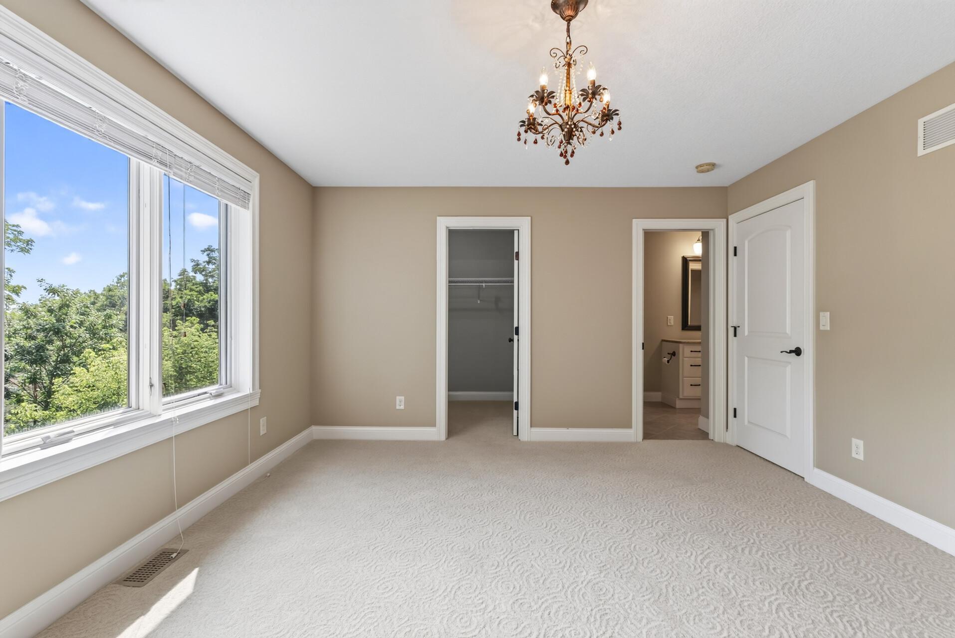 This spacious upper-level bedroom enjoys direct access to one of the home’s full bathrooms, adding an extra level of privacy and convenience.