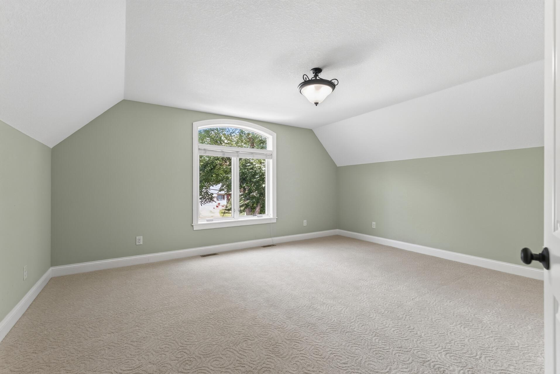 Positioned at the front of the home, this exceptionally spacious bedroom feels bright and grand, with raised ceilings adding an impressive sense of height and openness.