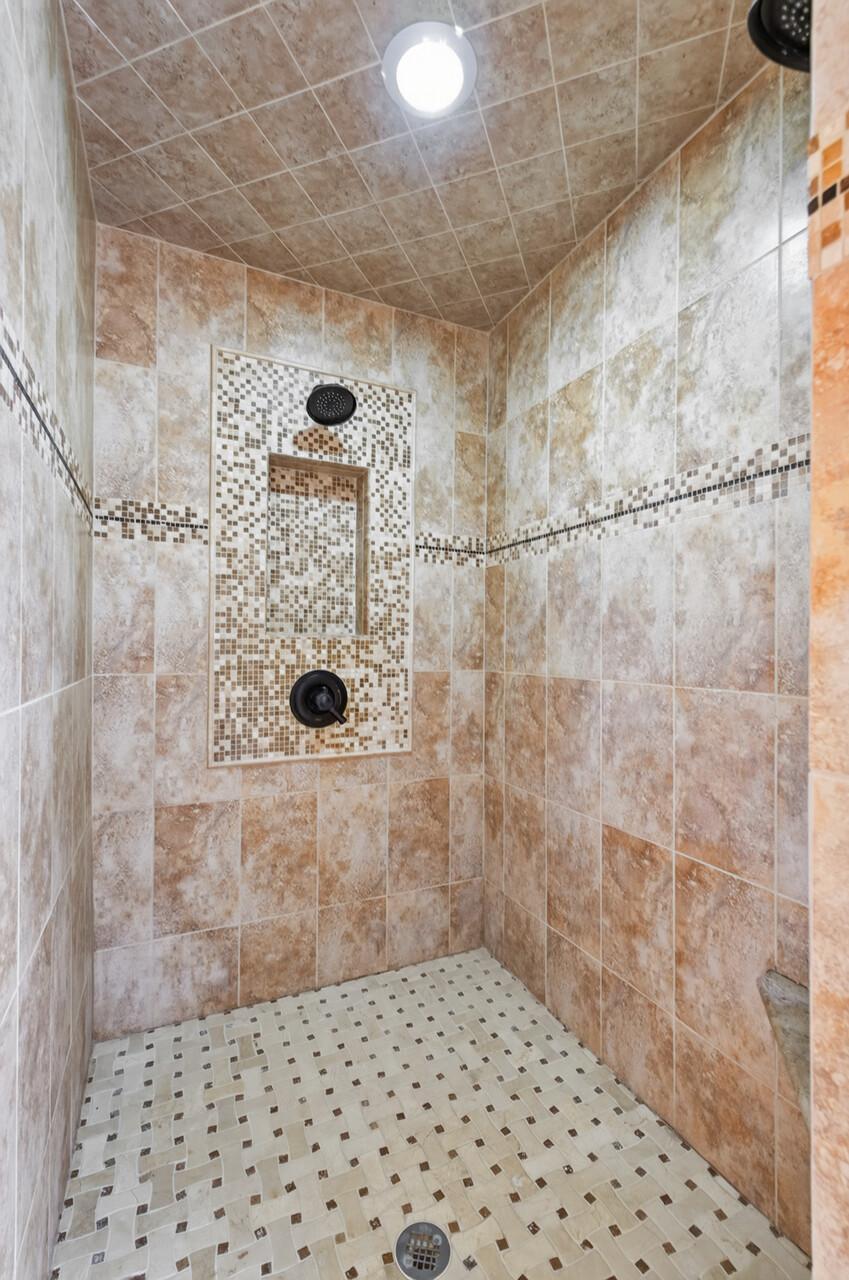 A generously sized, beautifully tiled walk-in shower creates a spa-like experience and brings an elevated sense of luxury to the primary bath.