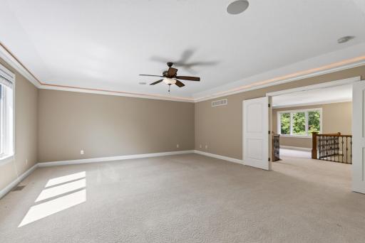 Cove lighting beautifully accentuates the primary suiteâs tray-vaulted ceiling, while a ceiling fan adds everyday comfort to this spacious and serene retreat.