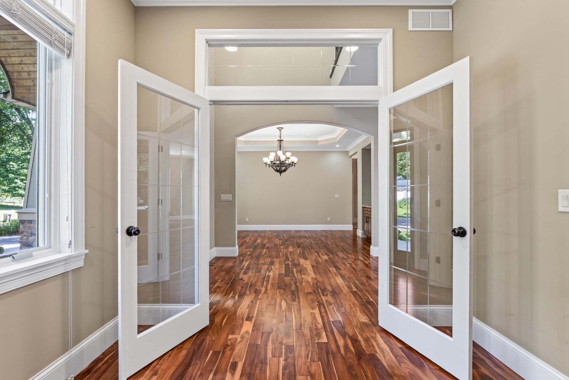 Double glass doors topped by a transom window create an elegant entrance to the main-level office while allowing natural light to flow beautifully through the space.