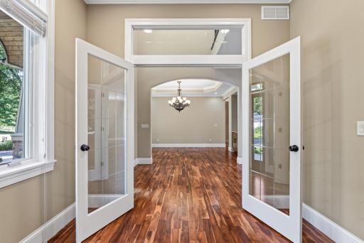 Double glass doors topped by a transom window create an elegant entrance to the main-level office while allowing natural light to flow beautifully through the space.