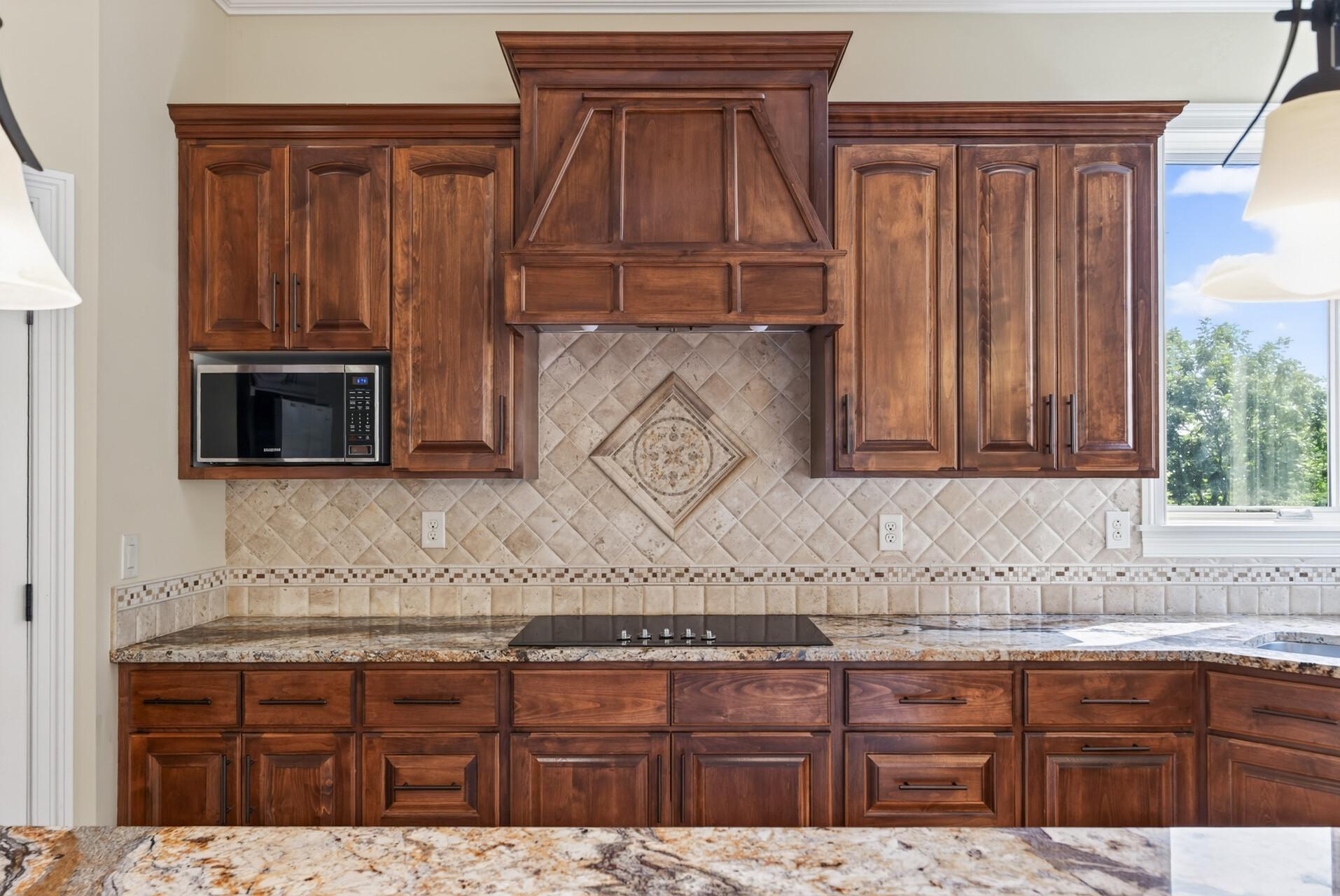 A custom vent hood creates a striking focal point, bringing architectural character and elevated craftsmanship to the heart of the kitchen.