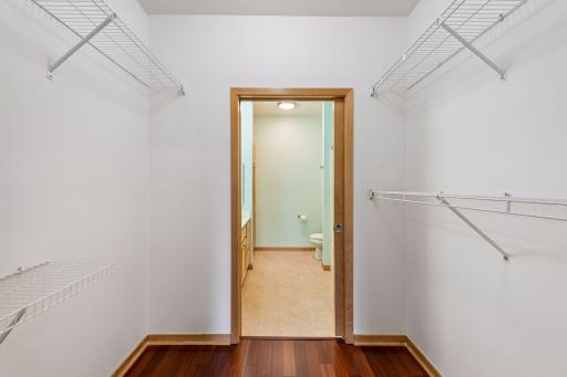 Generous walk-in closet with shelving on multiple sides and direct access to the primary bathroom.