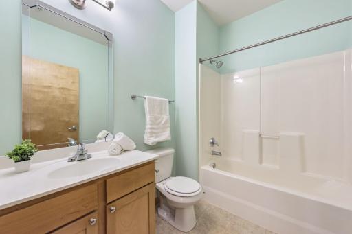Second full bathroom with tub/shower combination, vanity and additional storage.