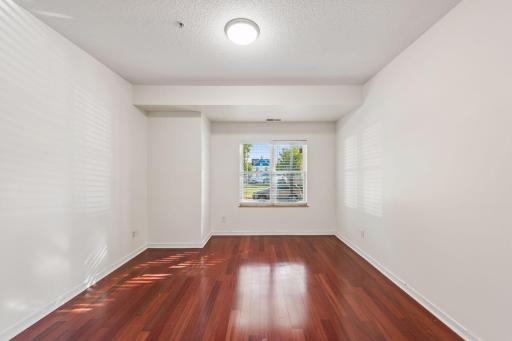 Spacious, freshly painted primary bedroom with a new light fixture and a large window bringing in plenty of natural light.
