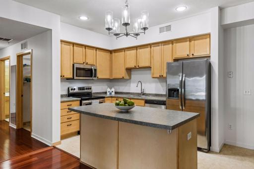 Large center island provides additional prep space and room for bar-style seating, creating a convenient spot for casual meals or morning coffee.