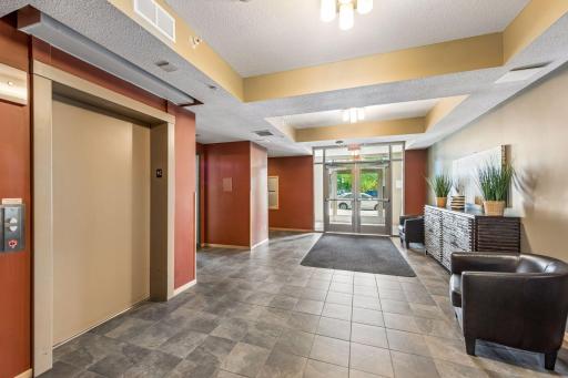Another view of the shared entrance lobby with elevator access and seating area. Unit 113 is conveniently located down the hallway to the left.