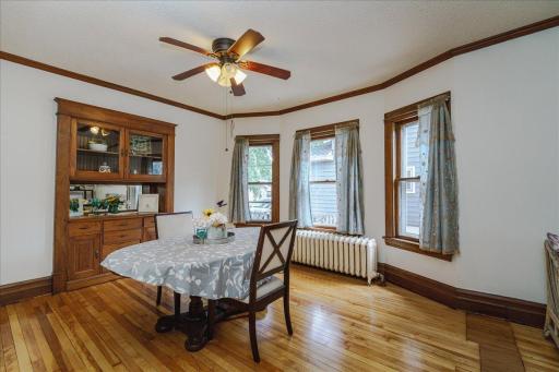 Gather around the table in a bright formal dining room framed by original wood trim.