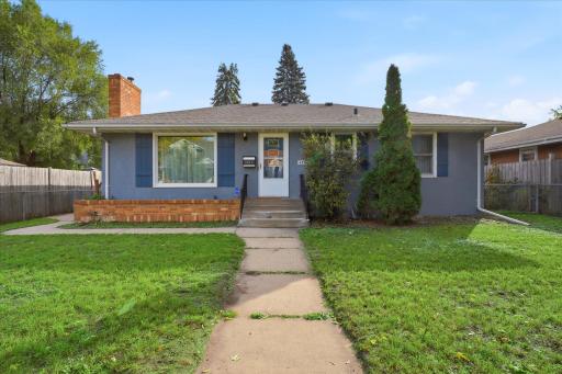 Front exterior showcases the home’s single-level design, spacious front yard, mature landscaping, and inviting entry.