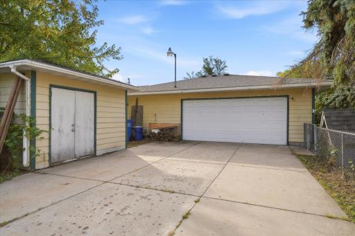 Spacious detached, heated garage featuring two 220V outlets, a full-length floor drain, wall-mounted A/C, 100-amp electrical service, and a separate gas meter. Ideal for vehicles, hobbies, and workshop projects.