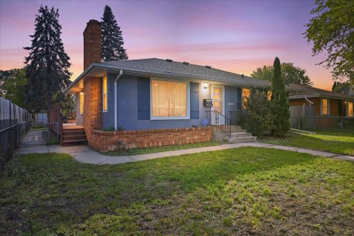 Welcoming exterior view of this classic rambler featuring a brick accent wall, mature landscaping, and a convenient new deck.