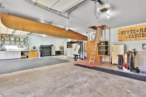 Spacious 4 car garage with an abundance of storage up above, includes an electric rail system to move things from the floor to the upper level.