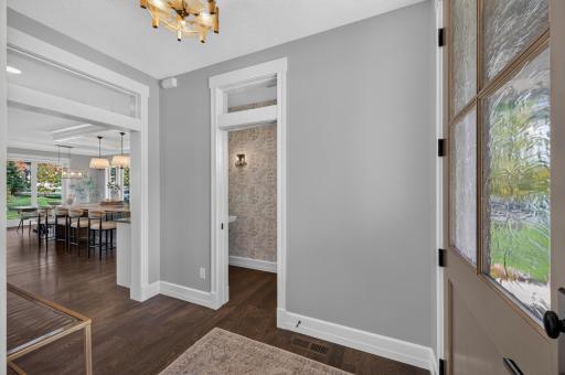 Main Level Half Bath sits adjacent to the Great Room, Kitchen, and Dining Room. Main Level boasts beautiful white oak hardwood flooring.