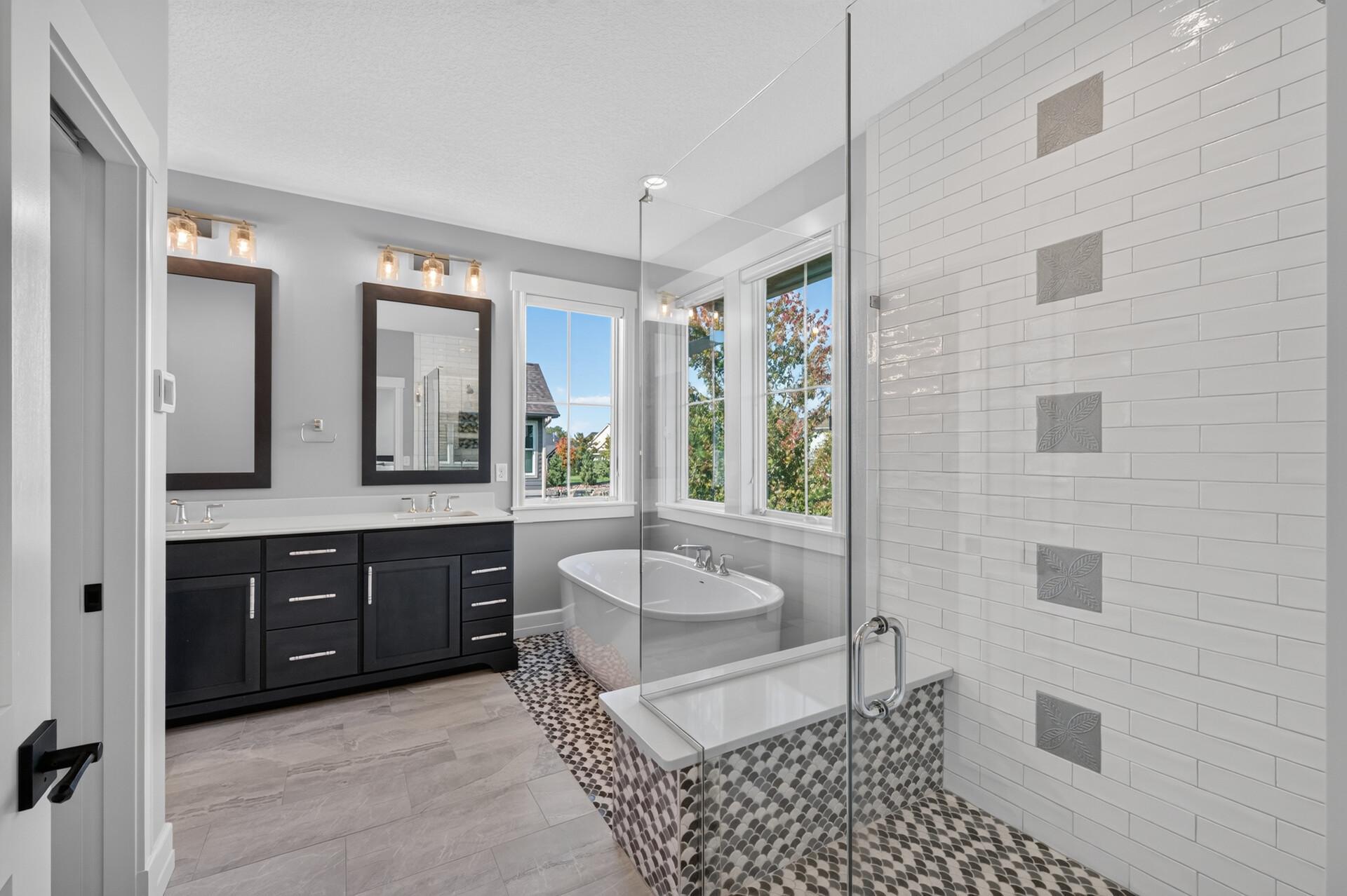 Owner's Suite Private Bathroom fit with In-Floor Heat, a tiled zero-entry shower, separate soaking tub, and double sinks