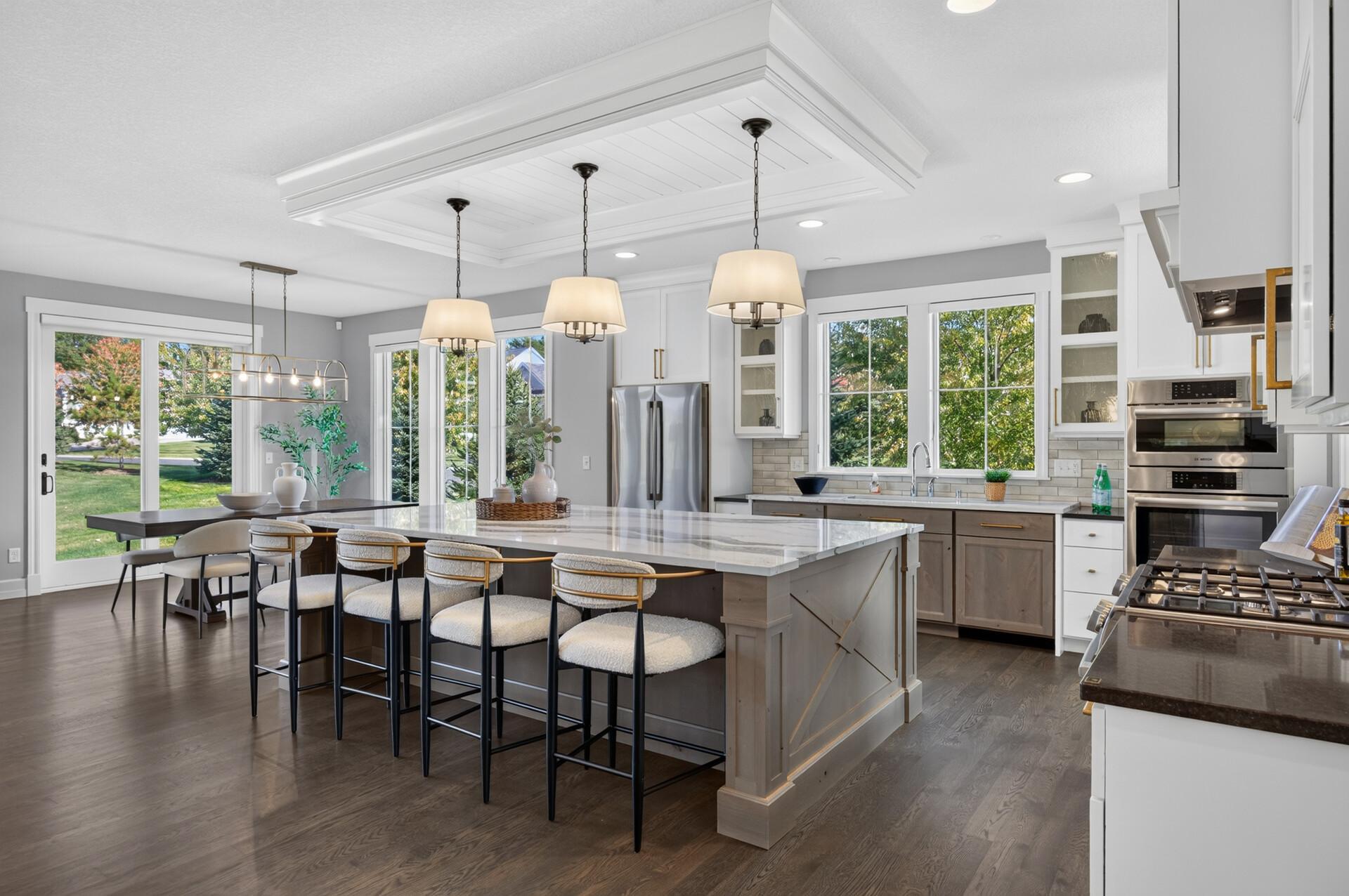 Stunning Kitchen features a large center island, Cambria countertops, knotty alder and painted custom cabinetry, and stainless steel Bosch appliances