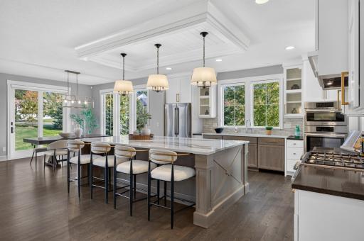 Stunning Kitchen features a large center island, Cambria countertops, knotty alder and painted custom cabinetry, and stainless steel Bosch appliances