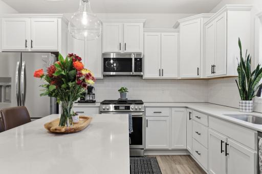 Gorgeous kitchen with quartz surfaces, stainless steel appliances, and a center island ideal for meal prep and casual dining.