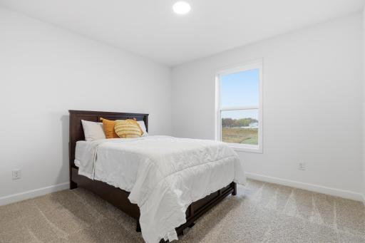 Comfortable secondary bedroom featuring plush carpeting, large windows, and peaceful neighborhood views.