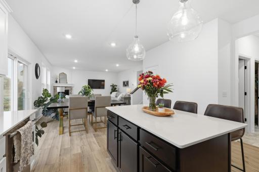 Open-concept living at its best, featuring a stunning center island, quartz countertops, and seamless flow into the dining and living areas.