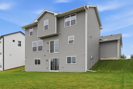 Rear elevation showcasing a spacious backyard and beautiful views of open green space.