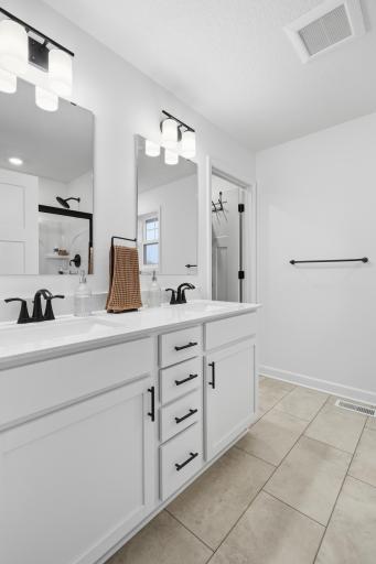 Bright and spacious bathroom with double sinks and stylish finishes, offering both convenience and elegance.