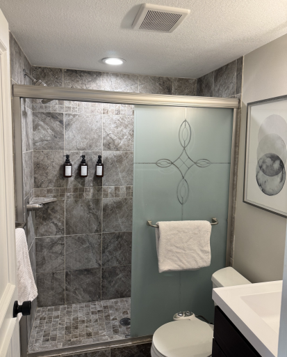 Lower level bath ft. custom tiled shower with mosaic accents