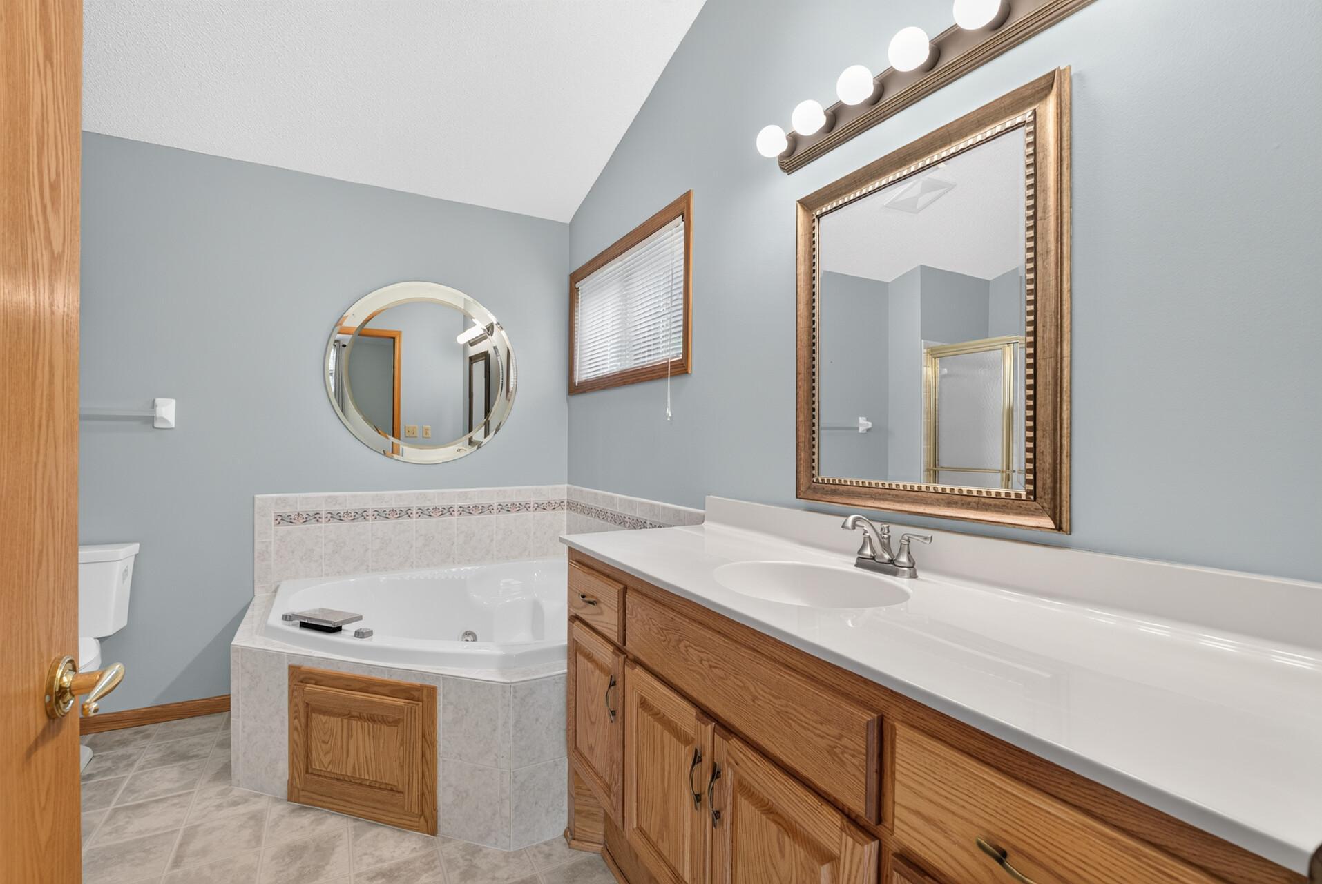 Relaxing whirlpool tub and oversized vanity which provides plenty of counter top space and storage as well.