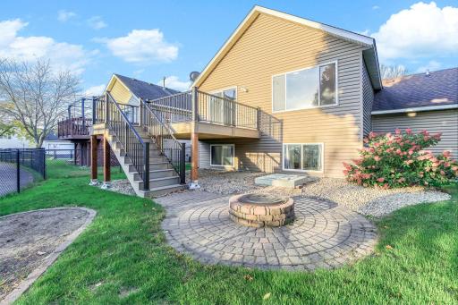 Refined paver patio anchored by a custom built-in fire pit, creating a polished, inviting outdoor retreat.